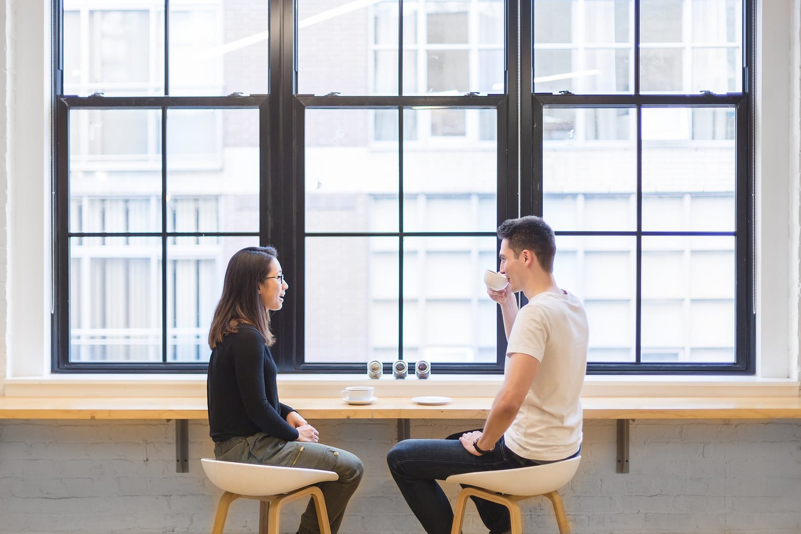 graphic of two people sitting at a table having a tough conversation over coffee